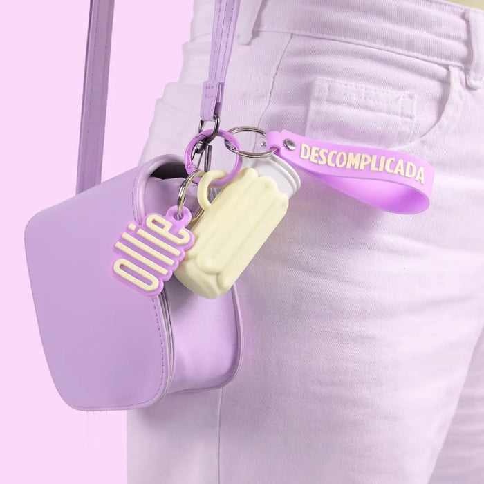 case porta-bastão ollie pendurado na alça de uma bolsa lilás
