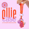case para bastão 3 em 1 ollie pendurado no zíper de uma mochila, selo the ollie club