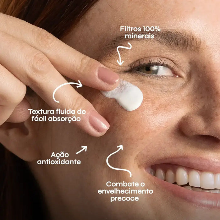 Modelo com sardas utilizando protetor solar mineral fluido de ação antioxidante, que combate o envelhecimento precoce.